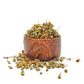 A bowl of dried loose chamomile flowers